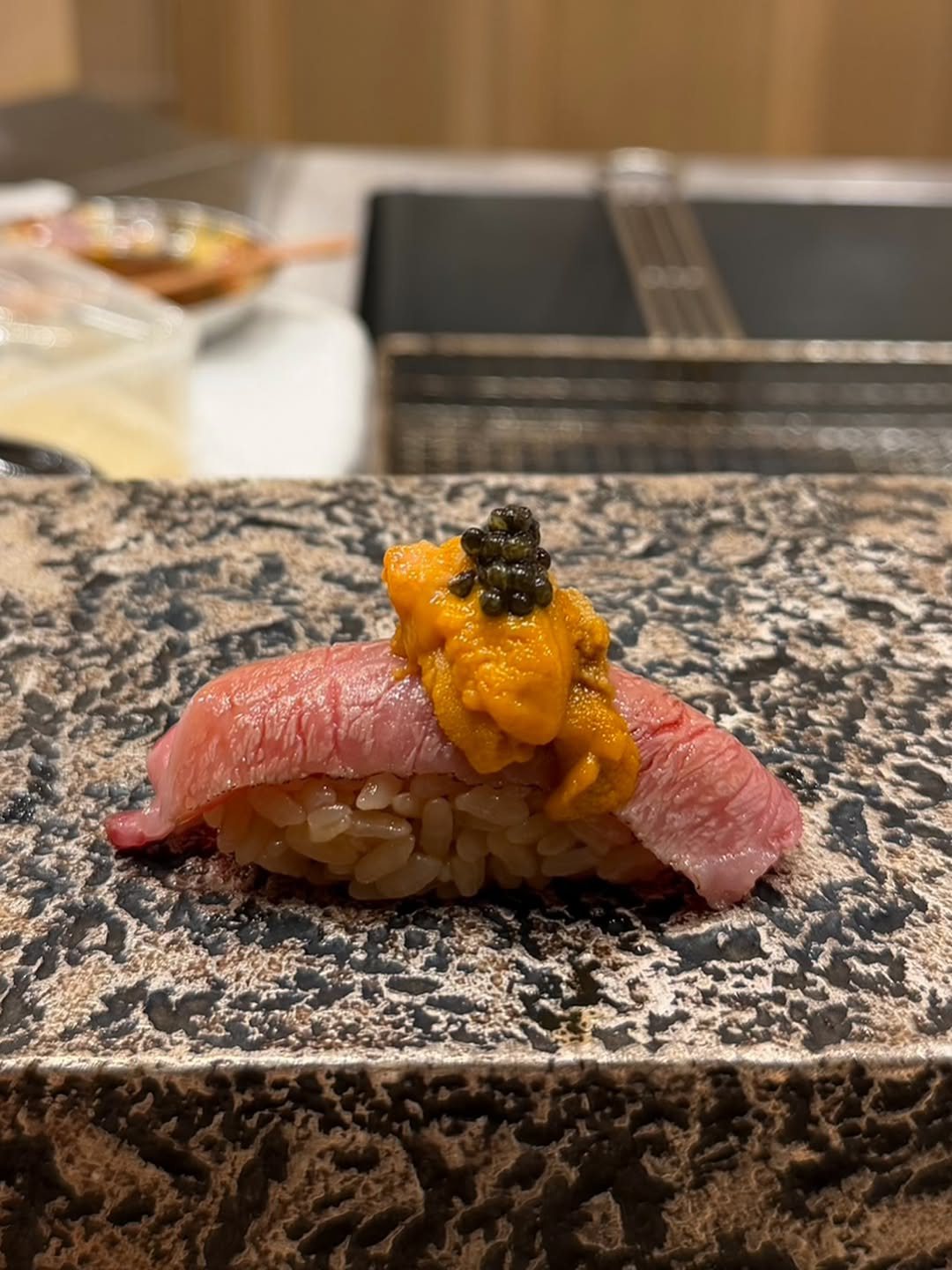 炙った肉にウニをのせた握り寿司